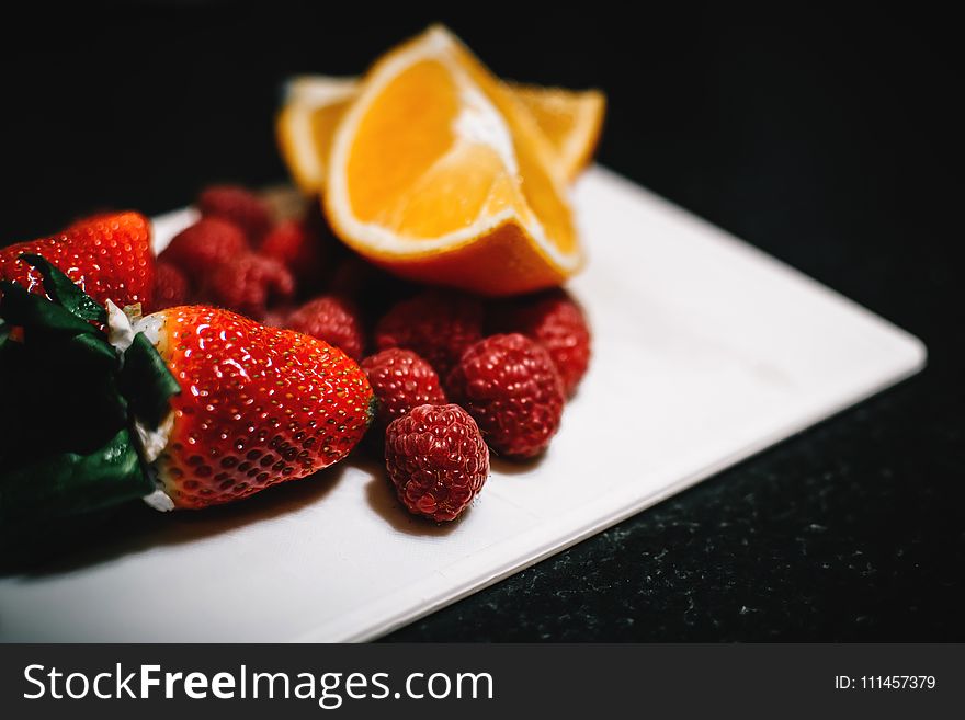 Strawberries and Sliced Wedge Oranges on White Dish