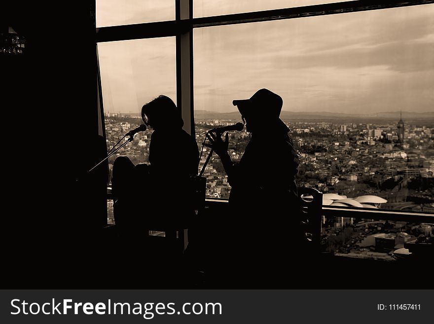 Silhouette of Two Women Singing in Sepia Photography