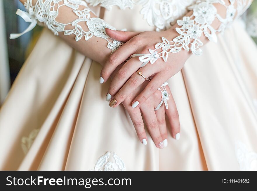 Bride`s hands in white dress