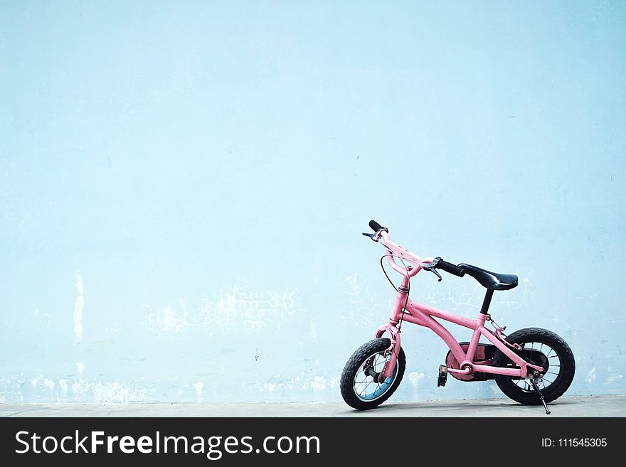 Toddler&x27;s Pink Bike Near Wall