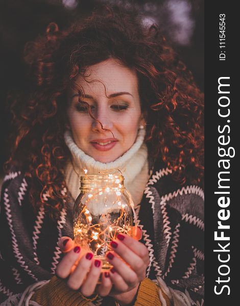 Woman Holding Mason Jar With String Lights Inside