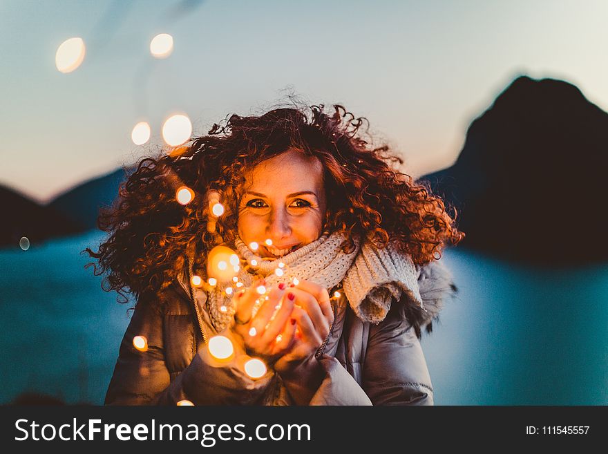 Woman Holding Brown Light during Nighttime