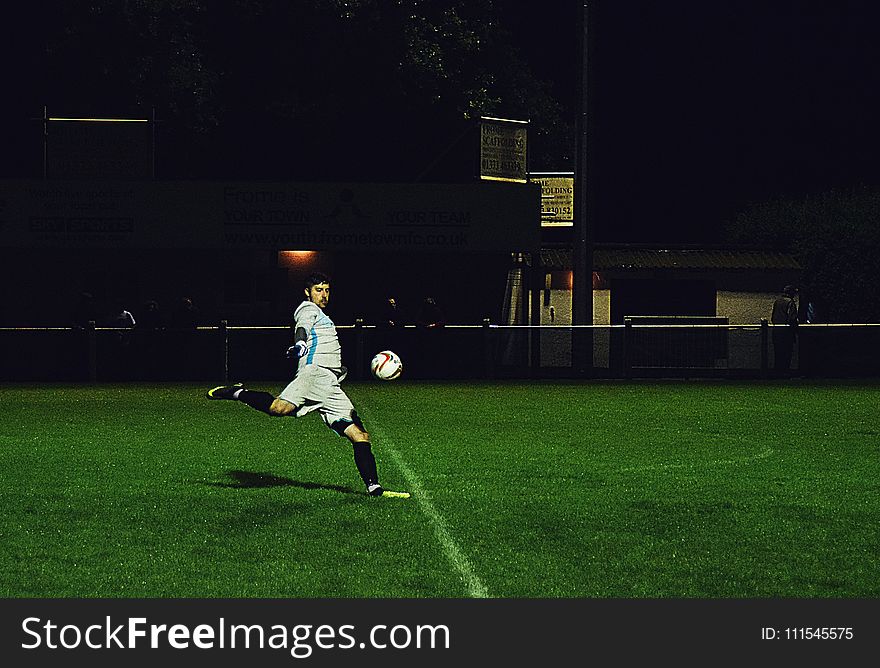 Person Kicks Soccer Ball in Field