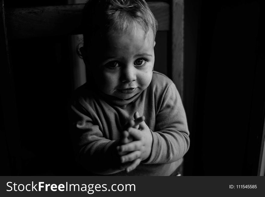 Grayscale Photo Of Baby Sitting On Chair