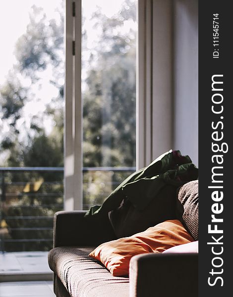 Brown Couch Beside Clear Glass Panel Door