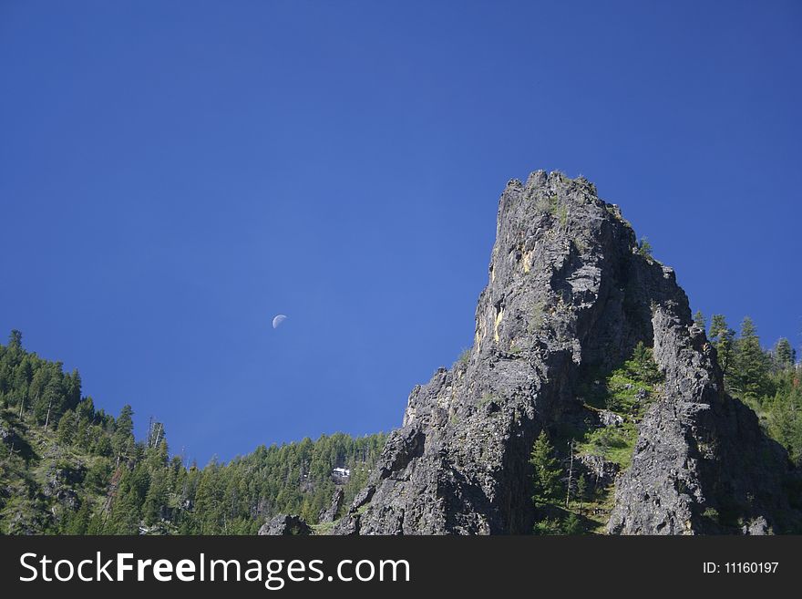 A rocky crag juts into the blue sky in the Idaho mountains. A rocky crag juts into the blue sky in the Idaho mountains.