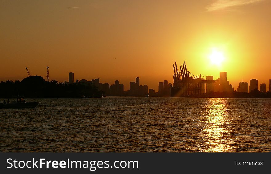 Silhouette of Buildings Near Body of Water Under Golden Hour