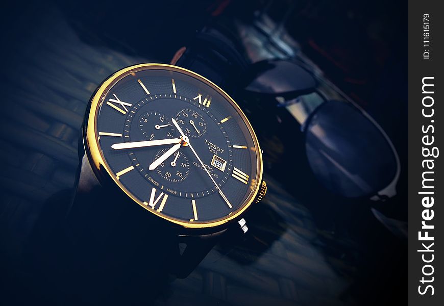 Round Gold-color Chronograph Watch With Black Strap at 7:36