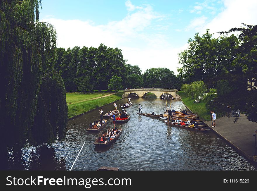 Group of People Ride on Jon Boats Near Bridge