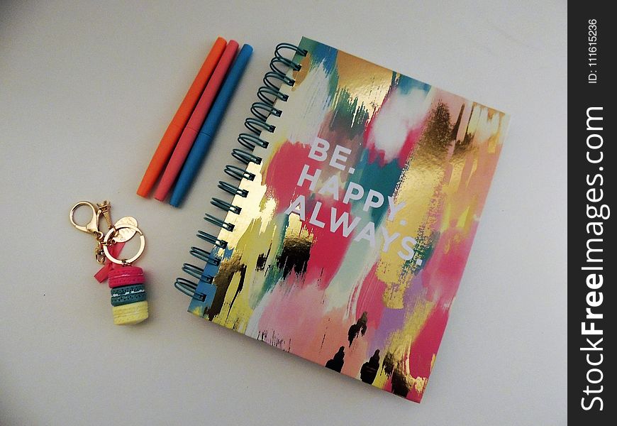 Be Happy Always Spring Notebook Beside Three Assorted-color Pens