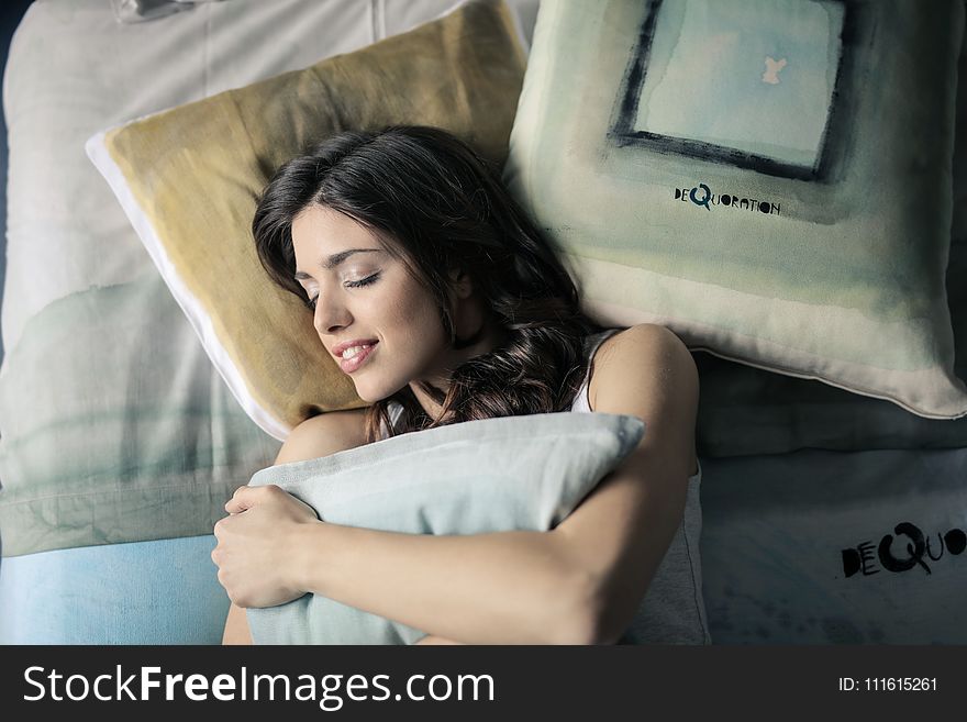 Woman Wearing White Tank-top Sleeping on Gray and White Bedspread
