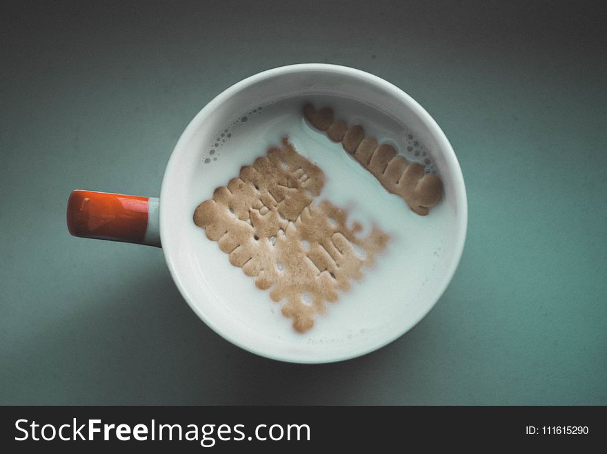 White Mug Filled White With Milk and Brown Biscuit