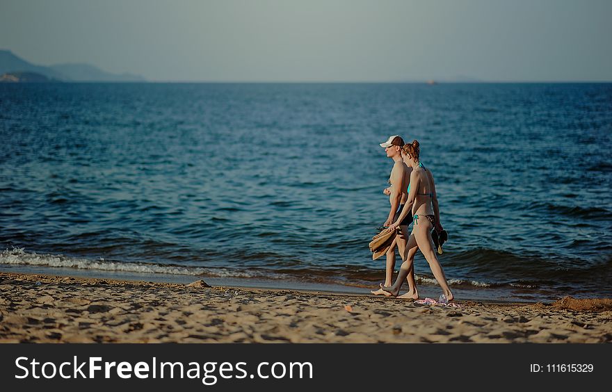 Couple Walking on the Beach at Daytime