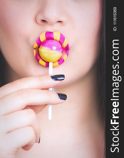 Woman Eating Pink And Yellow Lollipop