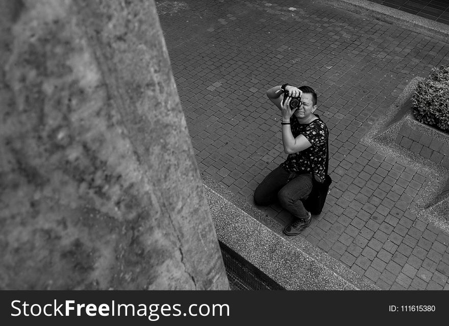 Grayscale Photography of Man Taking Picture