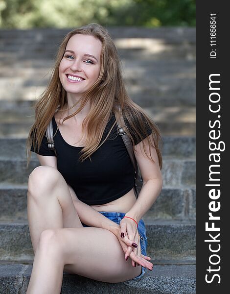 Young girl in shorts, sits on the steps. emotional portrait. life style