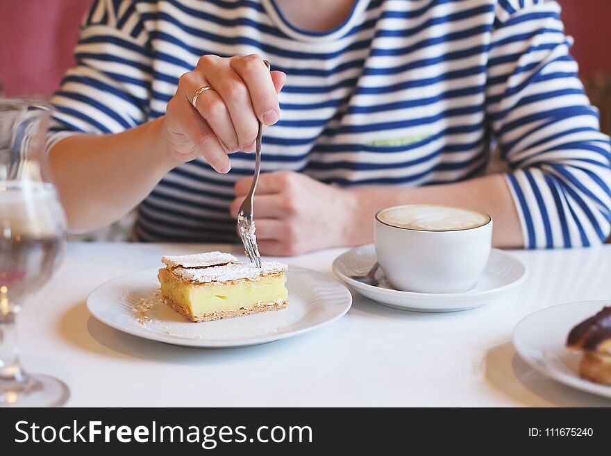 Girl in striped clothes eating fork with dessert