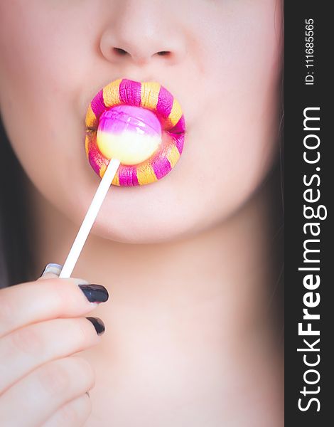 Woman Licking Pink and White Lollipop