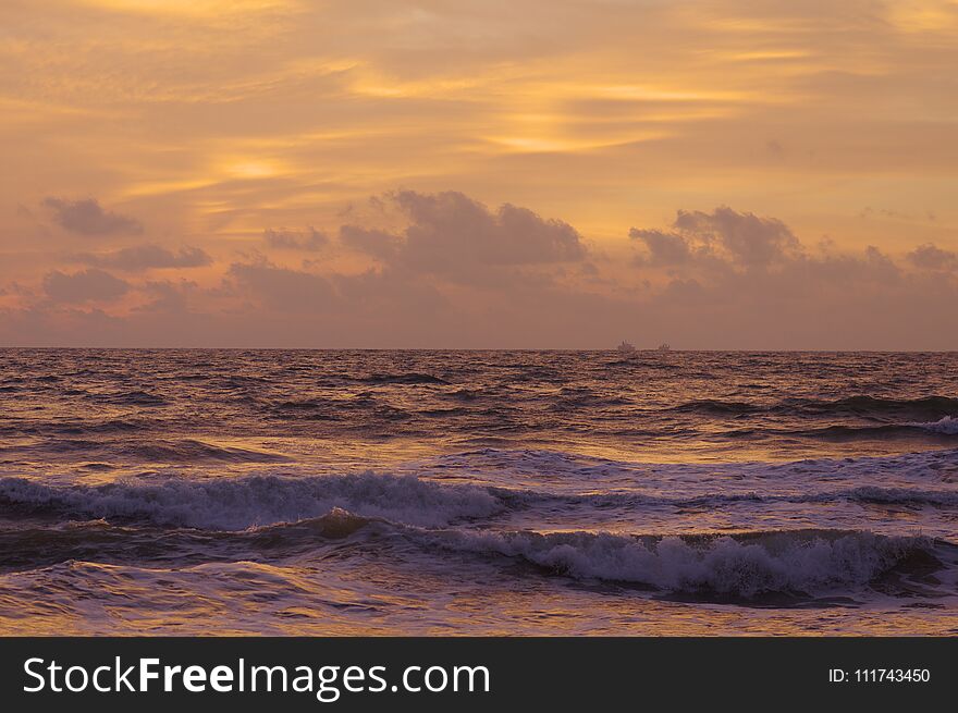 Sri-Lanka beach. red sunset at the ocean. cloudy.