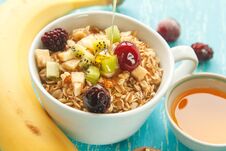 Cup Of Oat Flakes With Cherry, Kiwi, Blackberry, Egg, Walnut And Honey In Small Cup On A Turquoise Wooden Table. Royalty Free Stock Photography