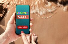 Summer Sale Promotional Concept. Top View Of Woman Customer Using Smart Phone With Advertising Deals On The Screen At Summer Royalty Free Stock Photography
