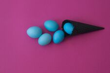 Easter. Blue Eggs Are Poured From A Waffle Cone From Ice Cream. Black Waffle Cone. Royalty Free Stock Photos