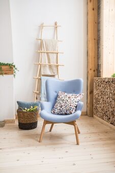 Interior Of Scandinavian Room. Blue Armchair With A Pillow On Them, A Wooden Staircase With A Towel Hanging On It, Basket With Tu Royalty Free Stock Image