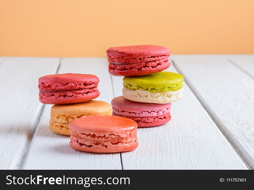 Different types color of macaroons on white wooden background
