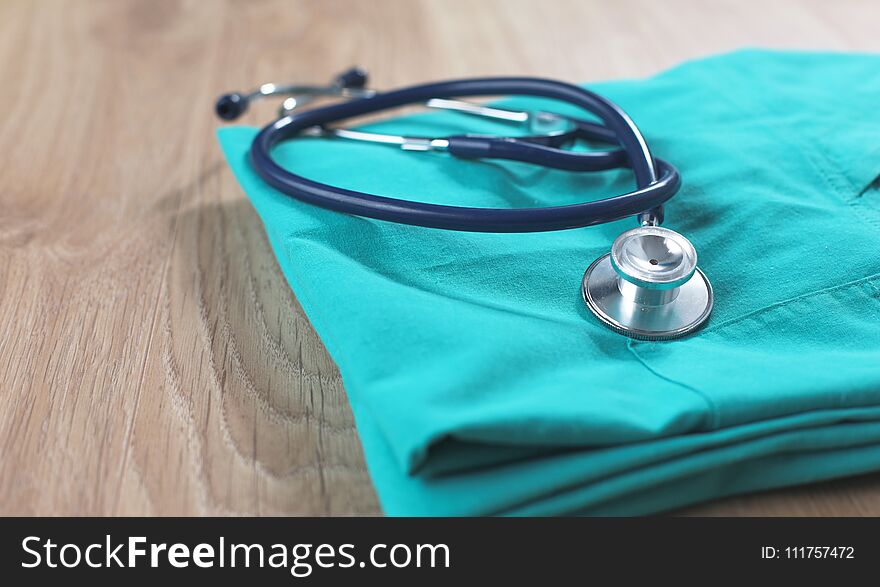 A stethoscope shaping a heart on a medical uniform, closeup