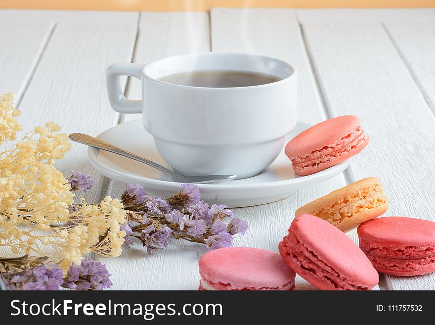 Different types color of macaroons Cup of hot tea on white wooden background Decorated with dried flowers Vintage style. Different types color of macaroons Cup of hot tea on white wooden background Decorated with dried flowers Vintage style