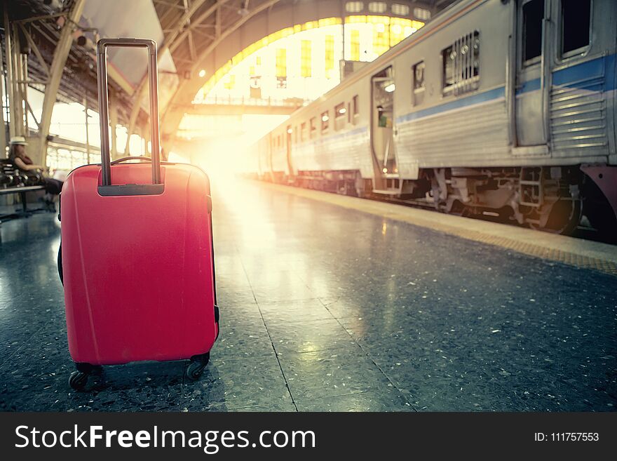 Red traveling luggage in trains station