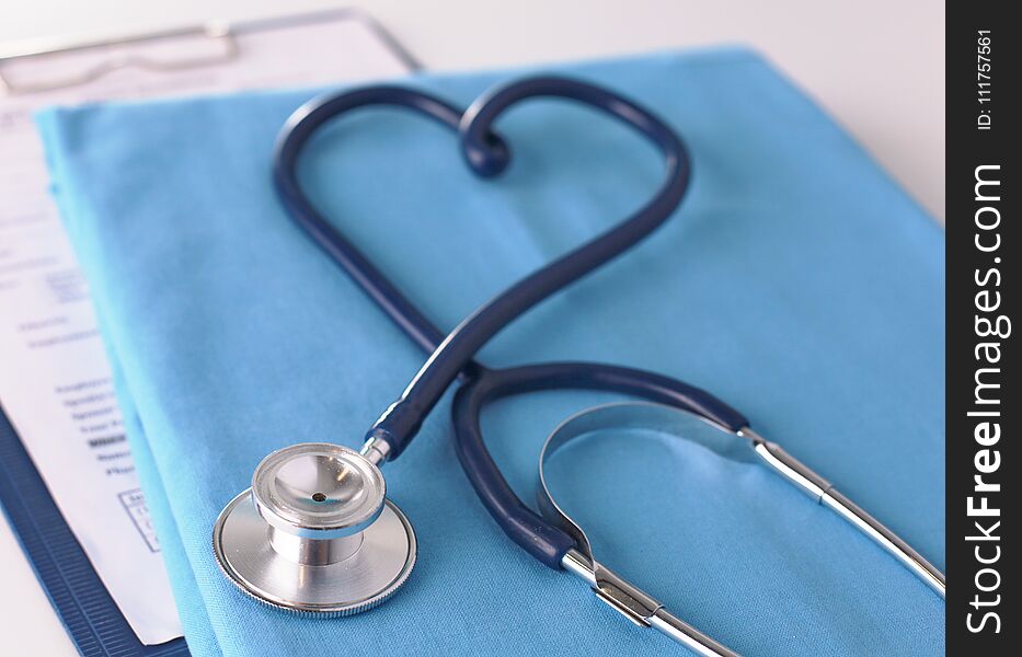 A stethoscope shaping a heart on a medical uniform, closeup