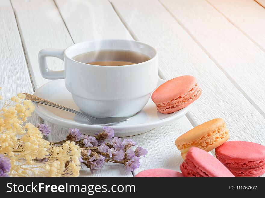 Different types color of macaroons Cup of hot tea on white wooden background Decorated with dried flowers Vintage style. Different types color of macaroons Cup of hot tea on white wooden background Decorated with dried flowers Vintage style
