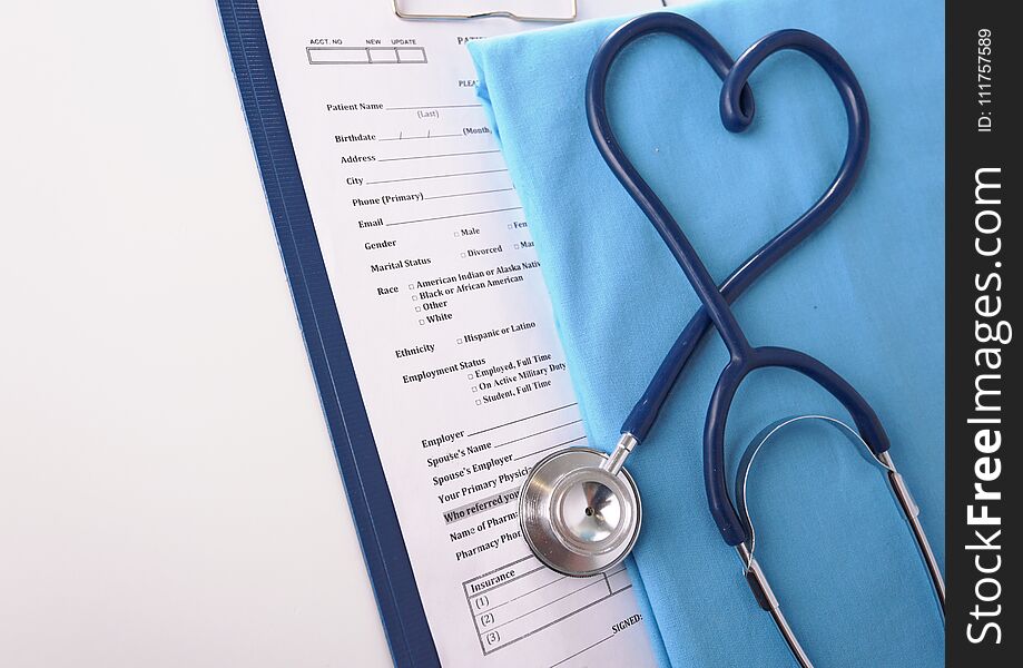 A stethoscope shaping a heart on a medical uniform, closeup.