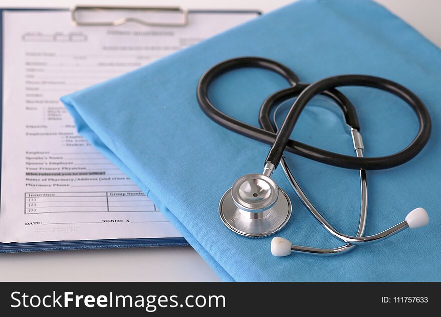 A stethoscope shaping a heart on a medical uniform, closeup