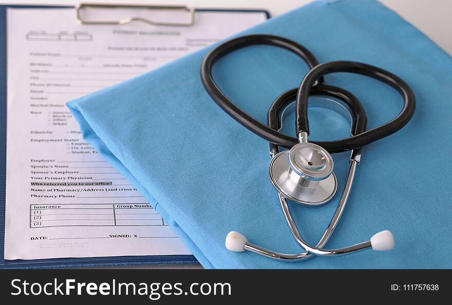 A stethoscope shaping a heart on a medical uniform, closeup.