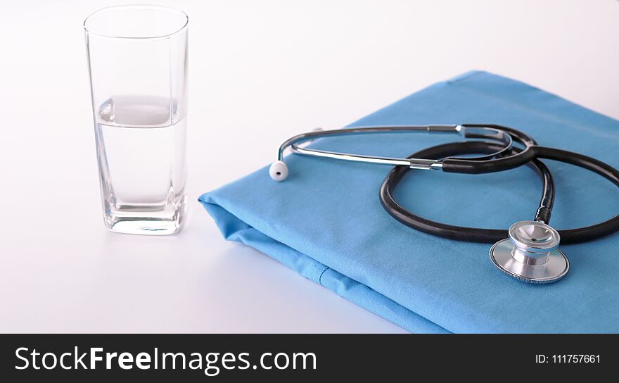 A stethoscope shaping a heart on a medical uniform, closeup