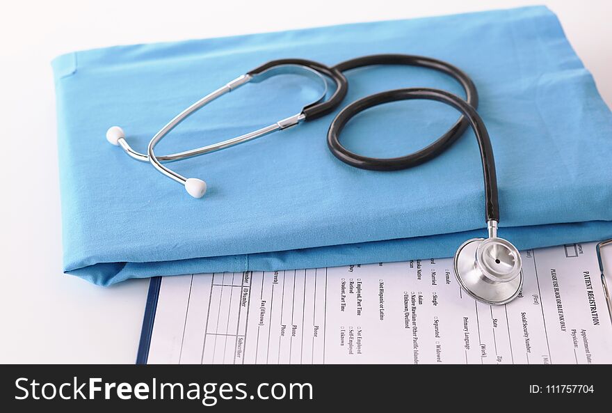 A stethoscope shaping a heart on a medical uniform, closeup.