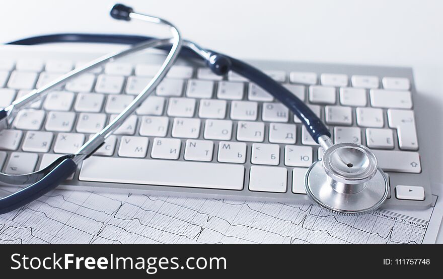 A stethoscope is on the keyboard of a computer