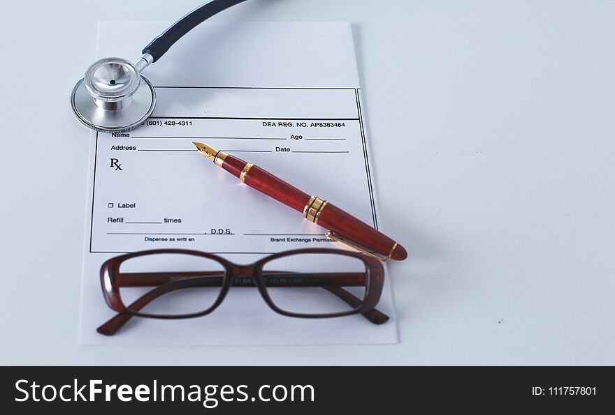 Doctor`s workspace working table with patient`s discharge blank paper form, medical prescription, stethoscope on desk