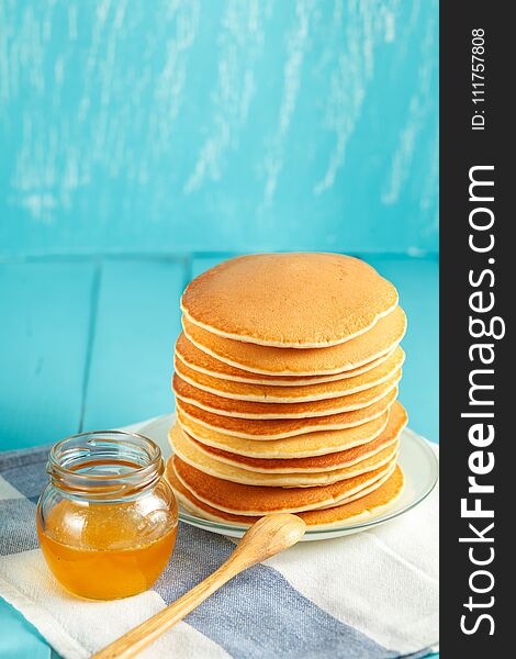 Vertical photo of stack of pancake with honey and butter