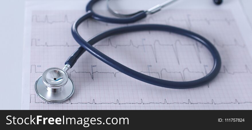 Stethoscope on cardiogram concept for heart care on the desk.blue toned images.