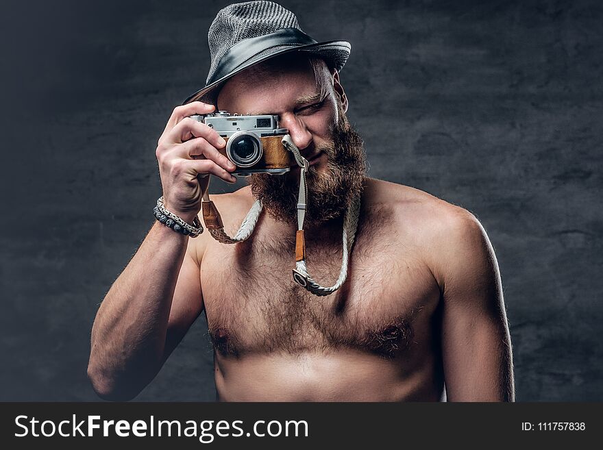 Bearded male holds vintage slr photo camera.