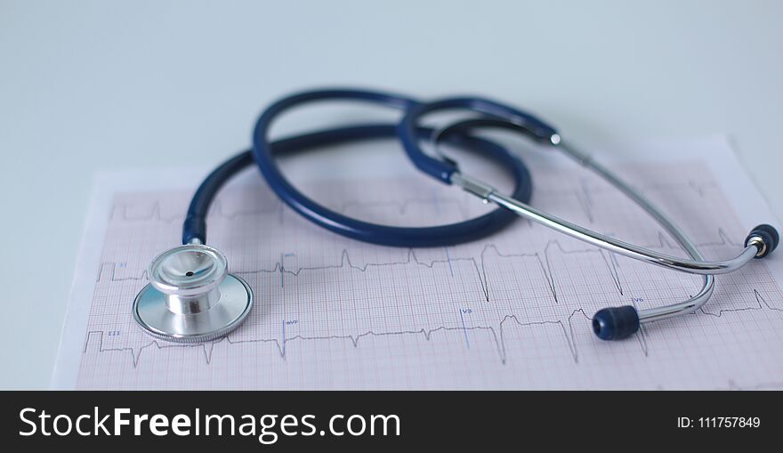 Stethoscope on cardiogram concept for heart care on the desk.blue toned images