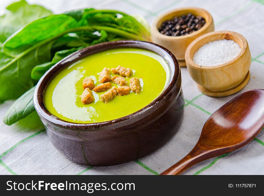 The spinach soup served on wooden board