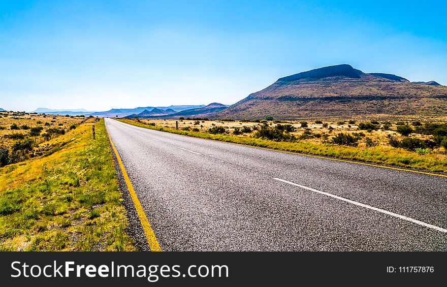 Long Straight Road through the Endless wide open landscape of the semi desert Karoo Region in Free State and Eastern Cape province