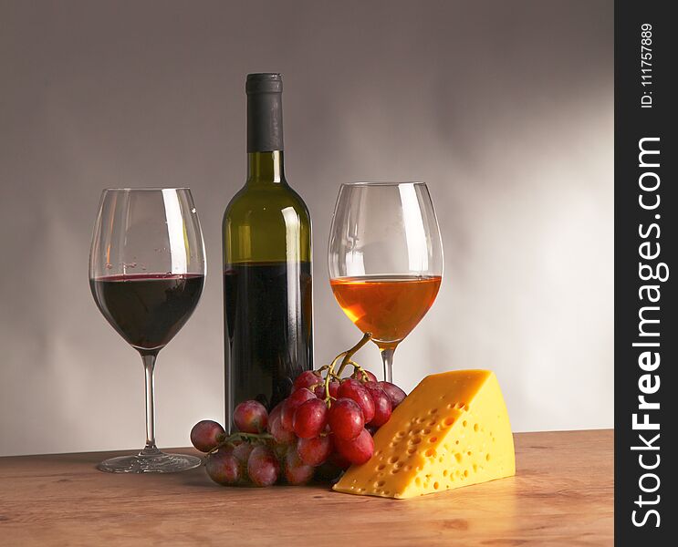Still life with glass and bottle of wine, cheese and grapes