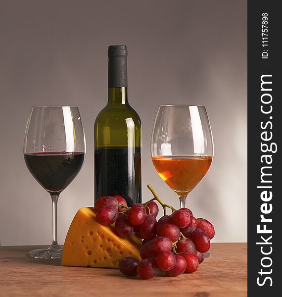 Still life with glass and bottle of wine, cheese and grapes