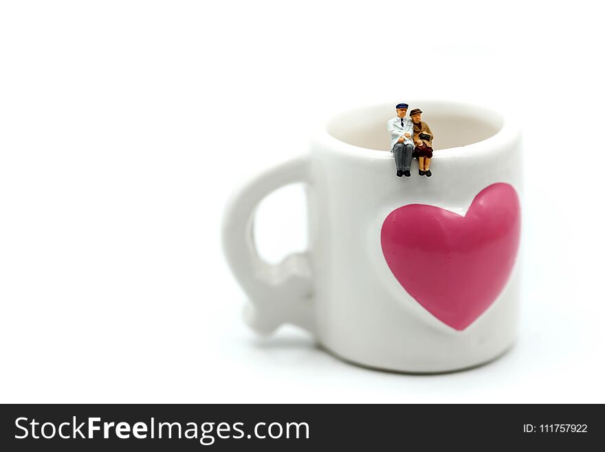 Miniature people : couple of love sitting on cup.