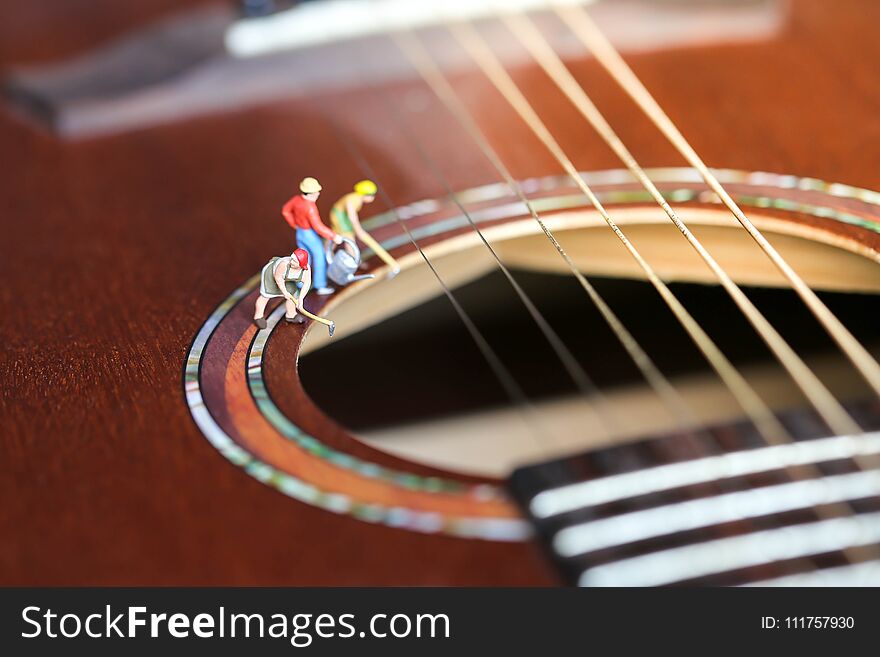 Miniature people : worker team with acoustic guitar,time of relax or music relax,stationary,education concept.